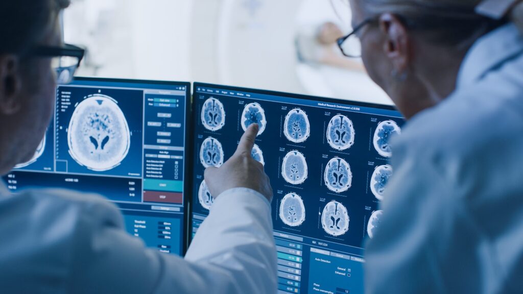 Dois médicos olhando para um monitor de computador observando detalhes da medicina personalizada