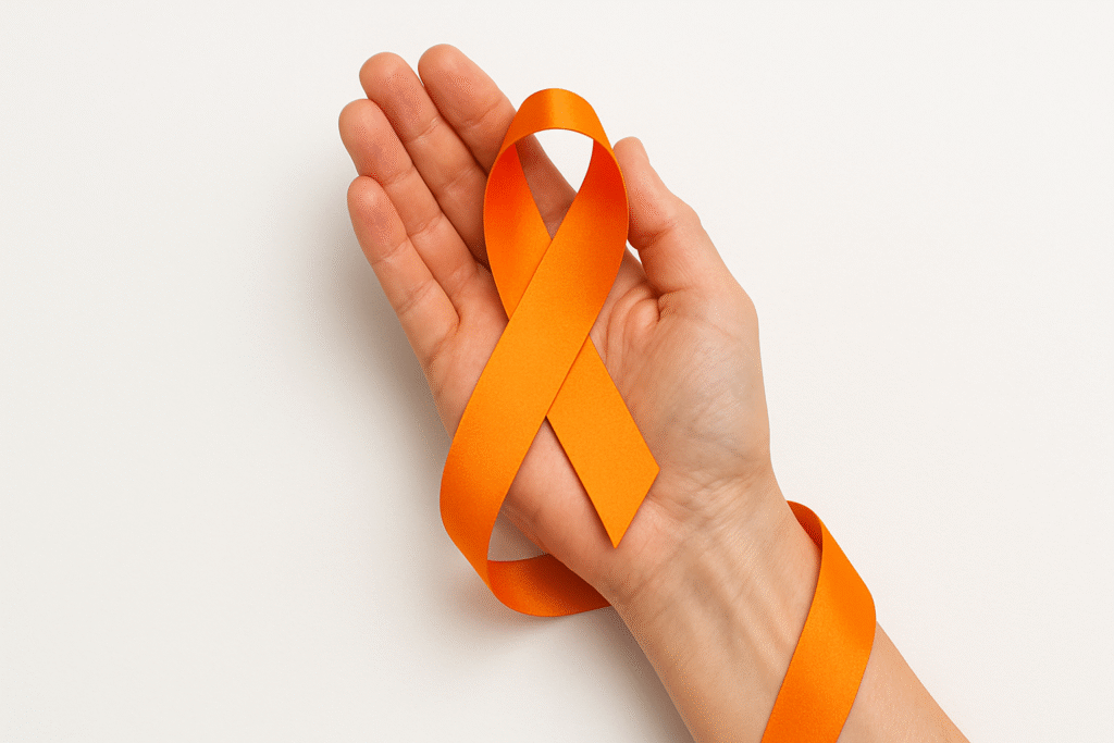 mão segurando fita do agosto laranja, mês de conscientização do diagnóstico da esclerose múltipla